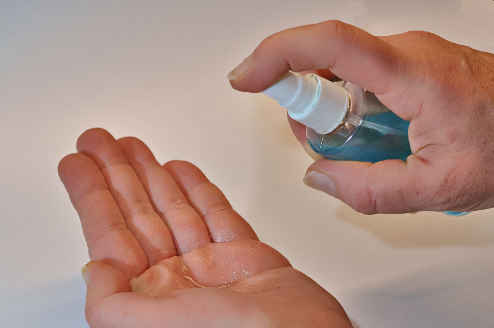 Person spraying sanitizer on their hands